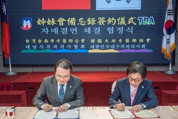 최문철 회장(오른쪽)과 타이난시 치과의사회장이 협약서에 서명하고 있다.