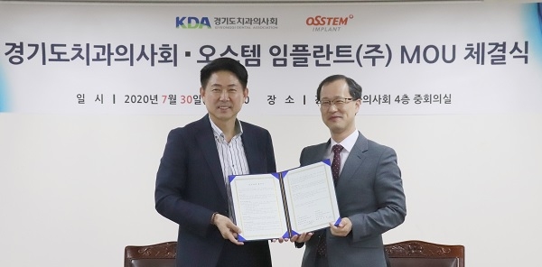오스템 엄태관 대표(왼쪽)와 경치 최유성 회장이 협약서를 보이고 있다.