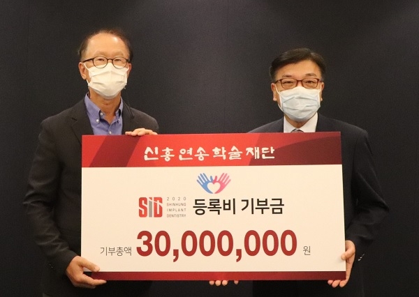 한중석 한국치과대학협의회장(오른쪽)이 신흥연송학술재단 이승종 이사장에게서 전국 치과대학 기부금을 받았다.