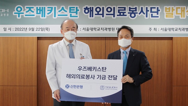 진옥동 신한은행장(오른쪽)이 구영 서울대치과병원장에게 우즈베키스탄 해외 의료봉사 기금을 전달했다.